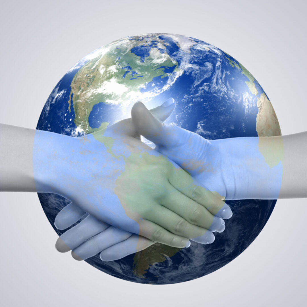 Two hands shaking in front of Earth symbolizing global cooperation.